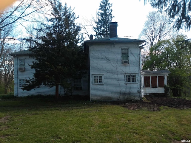 rear view of house with a yard and a sunroom