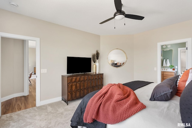 bedroom with ensuite bath, ceiling fan, and light carpet