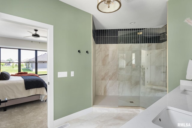 bathroom featuring a tile shower, ceiling fan, and sink