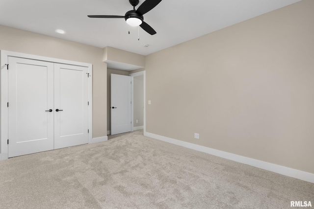 unfurnished bedroom with a closet, light colored carpet, and ceiling fan