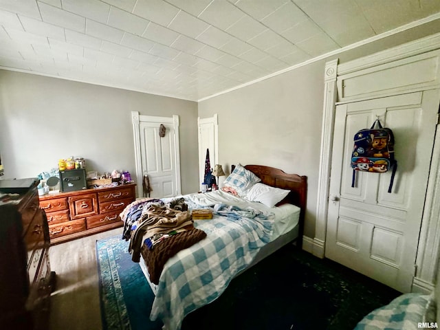 bedroom with crown molding and dark hardwood / wood-style floors