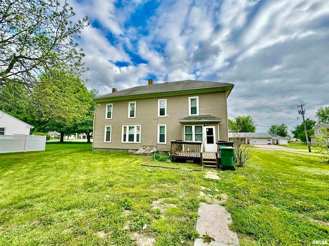 back of house featuring a wooden deck and a yard