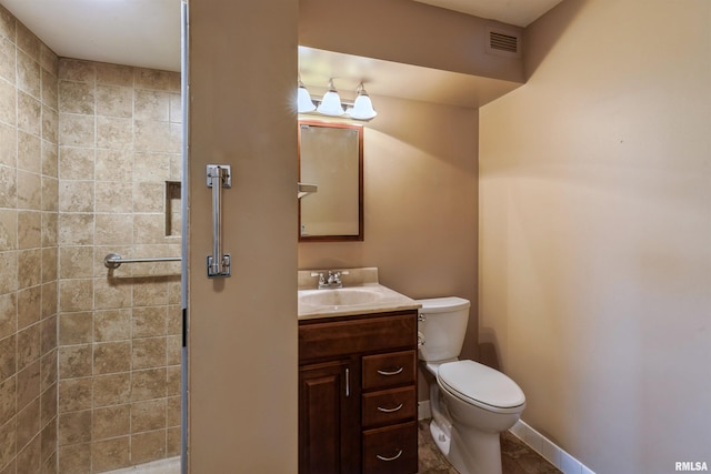 bathroom with tile flooring, tiled shower, oversized vanity, and toilet