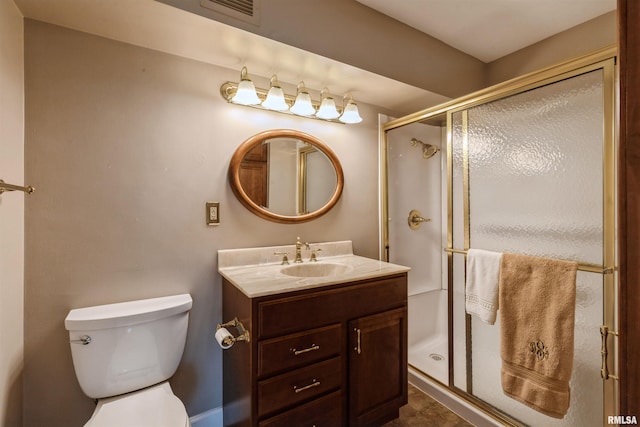 bathroom featuring a shower with shower door, vanity, toilet, and tile floors