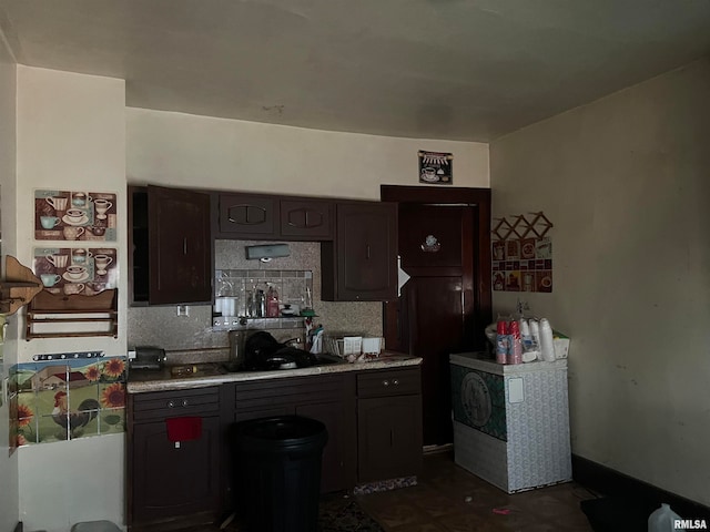 kitchen featuring dark brown cabinets and tasteful backsplash