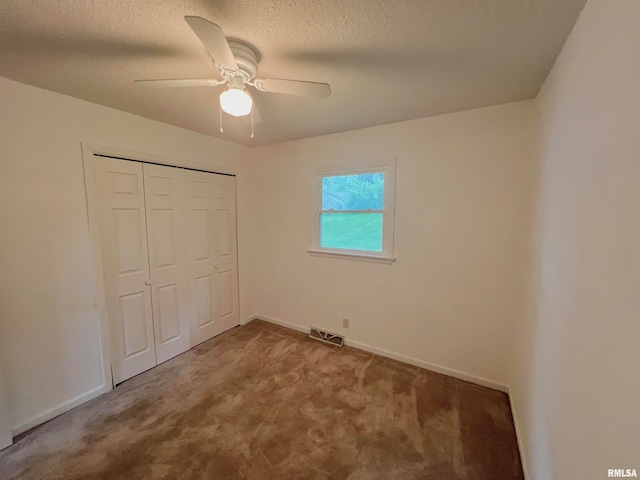 unfurnished bedroom featuring a closet, carpet, a textured ceiling, and ceiling fan