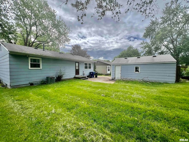 back of house with a patio, a lawn, and central AC