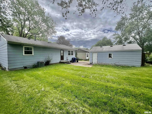 rear view of property featuring cooling unit and a lawn