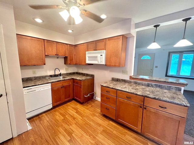 kitchen with white appliances, sink, hanging light fixtures, light hardwood / wood-style floors, and ceiling fan