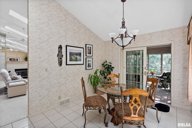 tiled dining space featuring vaulted ceiling with beams and a chandelier