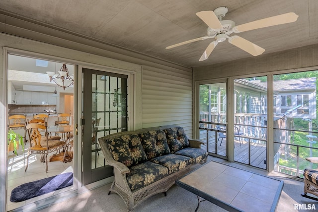 sunroom / solarium featuring ceiling fan with notable chandelier