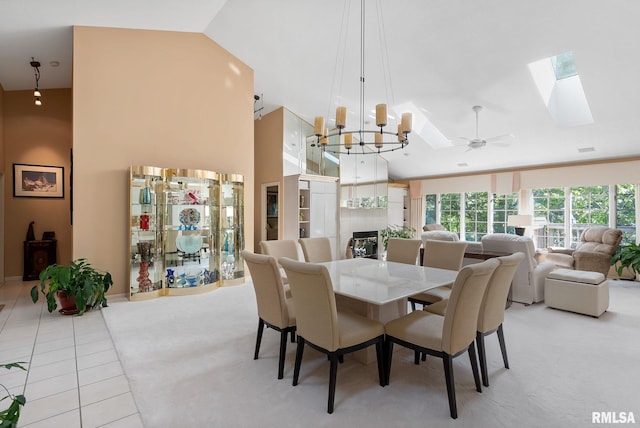 dining room featuring ceiling fan with notable chandelier, lofted ceiling, and light tile patterned flooring