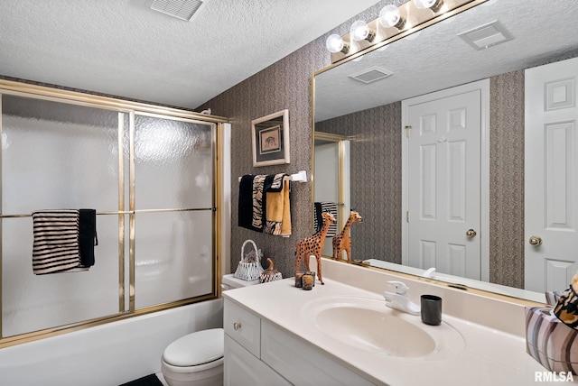 full bathroom featuring shower / bath combination with glass door, vanity, a textured ceiling, and toilet