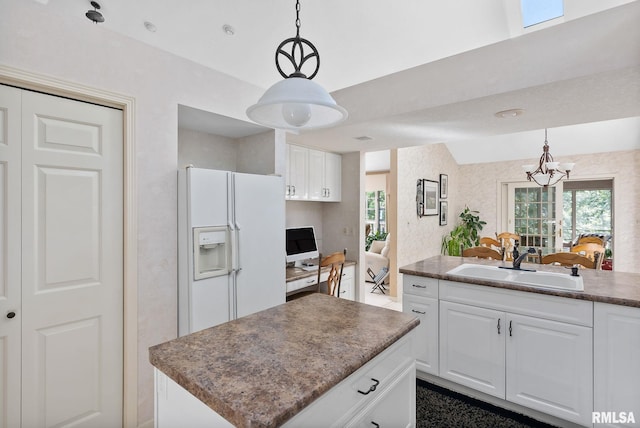 kitchen with white cabinetry, sink, and hanging light fixtures