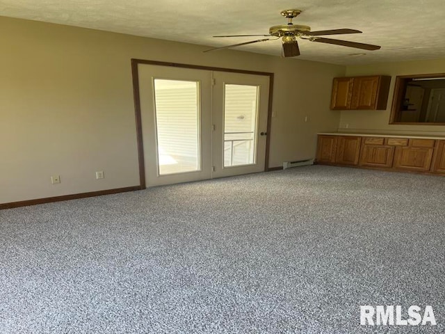 unfurnished living room with ceiling fan, a textured ceiling, carpet flooring, and a baseboard heating unit