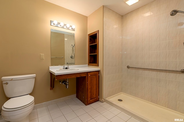 bathroom featuring tile patterned flooring, a tile shower, sink, and toilet