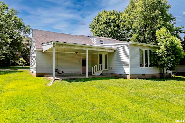 rear view of house featuring a yard and ceiling fan