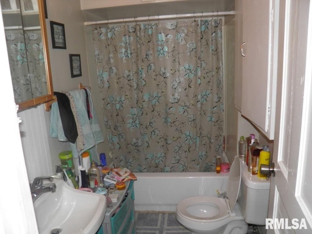 full bathroom featuring toilet, shower / tub combo with curtain, and a sink