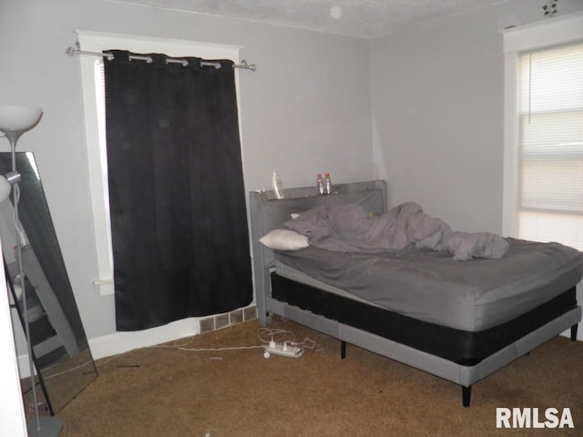 carpeted bedroom featuring baseboards and a textured ceiling