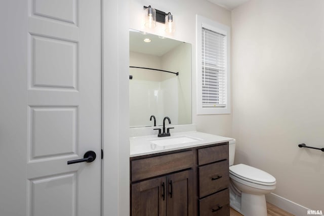 bathroom with a shower, wood-type flooring, vanity, and toilet