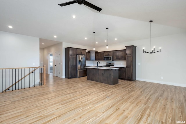 kitchen featuring appliances with stainless steel finishes, ceiling fan with notable chandelier, dark brown cabinetry, decorative light fixtures, and light hardwood / wood-style floors