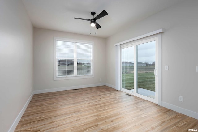 spare room with a wealth of natural light, light hardwood / wood-style flooring, and ceiling fan