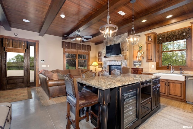 kitchen with light hardwood / wood-style flooring, beverage cooler, a fireplace, wooden ceiling, and sink