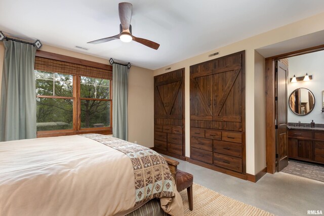 carpeted bedroom featuring sink, ceiling fan, and ensuite bath