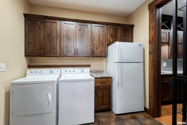 washroom with washer and clothes dryer and cabinet space