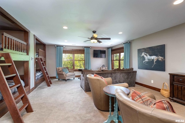 living area with light carpet, a wealth of natural light, and baseboards