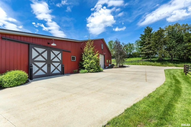 view of pole building with fence and a yard