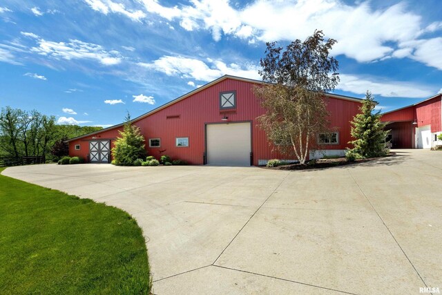 view of front of house with an outdoor structure, a garage, and a front lawn