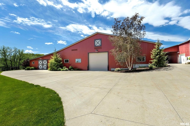 view of side of home featuring a garage and an outbuilding