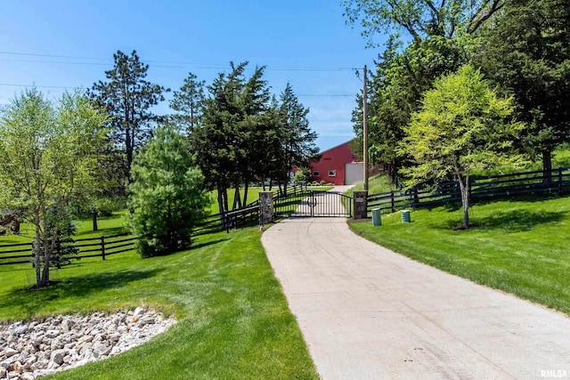 view of property's community featuring a gate, fence, and a lawn