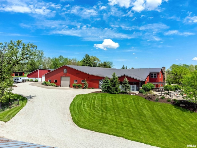 view of front of house featuring gravel driveway, a garage, and a front yard