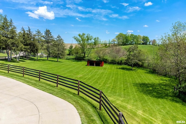 surrounding community with an outbuilding, a rural view, a yard, and fence