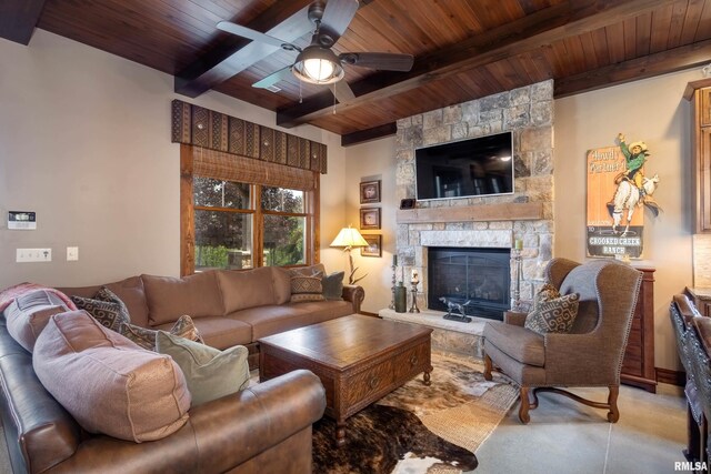 living room featuring beamed ceiling, wooden ceiling, a fireplace, and ceiling fan