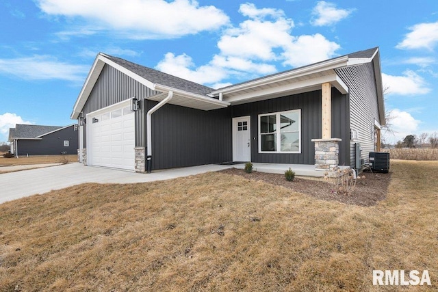 view of front of house featuring cooling unit, a garage, a front yard, and a porch