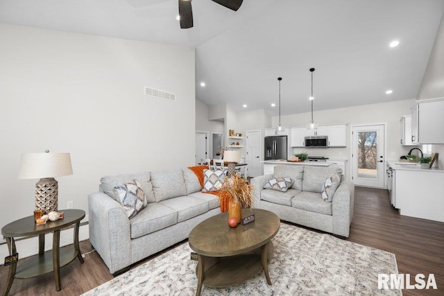 living room with dark hardwood / wood-style flooring, sink, high vaulted ceiling, and ceiling fan