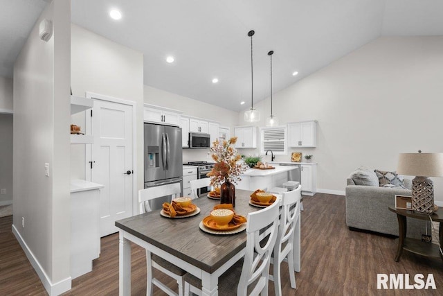 dining area featuring dark hardwood / wood-style floors, sink, and high vaulted ceiling