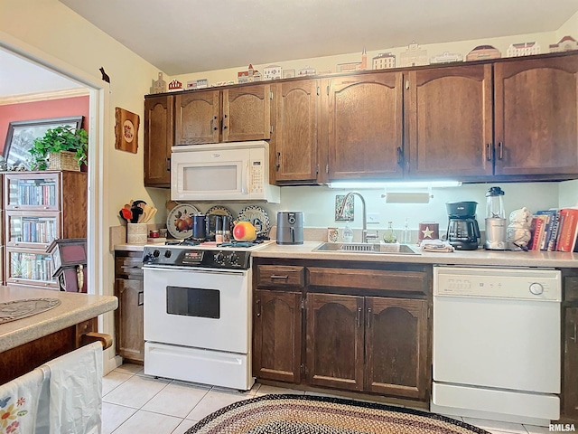 kitchen with light tile patterned flooring, sink, and white appliances