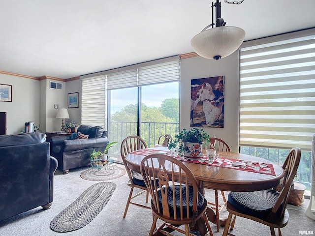 carpeted dining area with ornamental molding