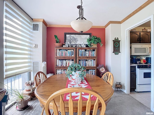 tiled dining room featuring crown molding