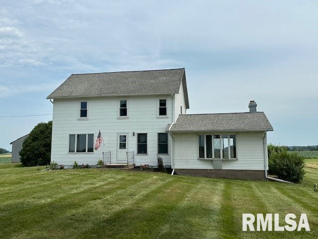 rear view of property with a lawn