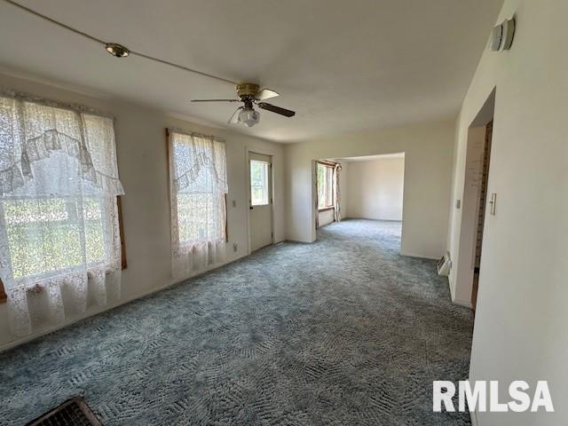 carpeted spare room with ceiling fan