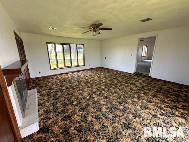 unfurnished living room featuring carpet floors and ceiling fan