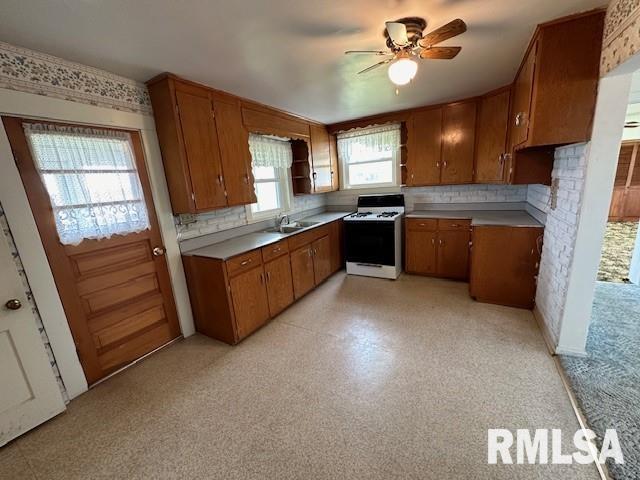 kitchen with white range oven, ceiling fan, and sink