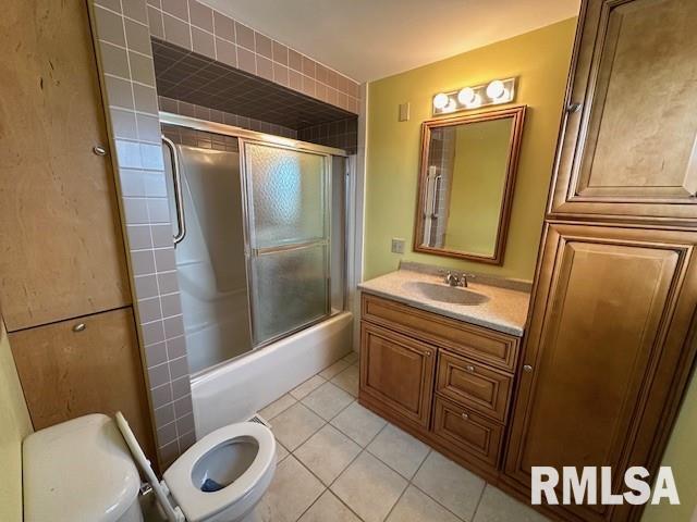 full bathroom with tile patterned flooring, vanity, enclosed tub / shower combo, and toilet