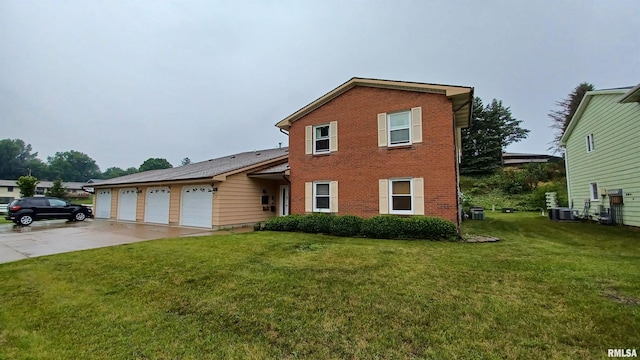 view of front of home with cooling unit, a garage, and a front yard