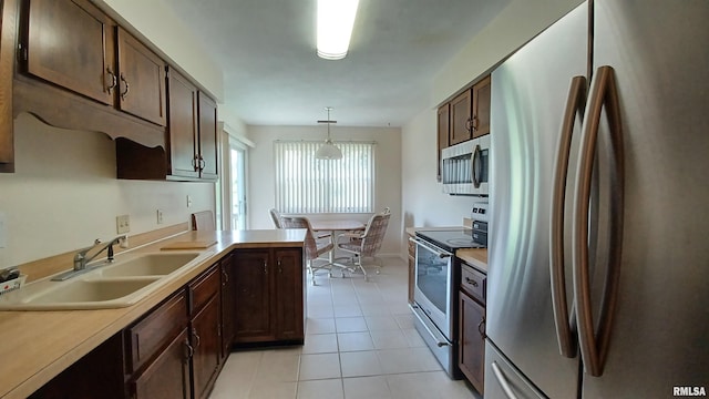 kitchen featuring appliances with stainless steel finishes, dark brown cabinets, sink, light tile patterned floors, and hanging light fixtures